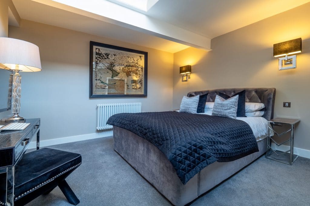 Modern grey bedroom with navy quilted bedspread